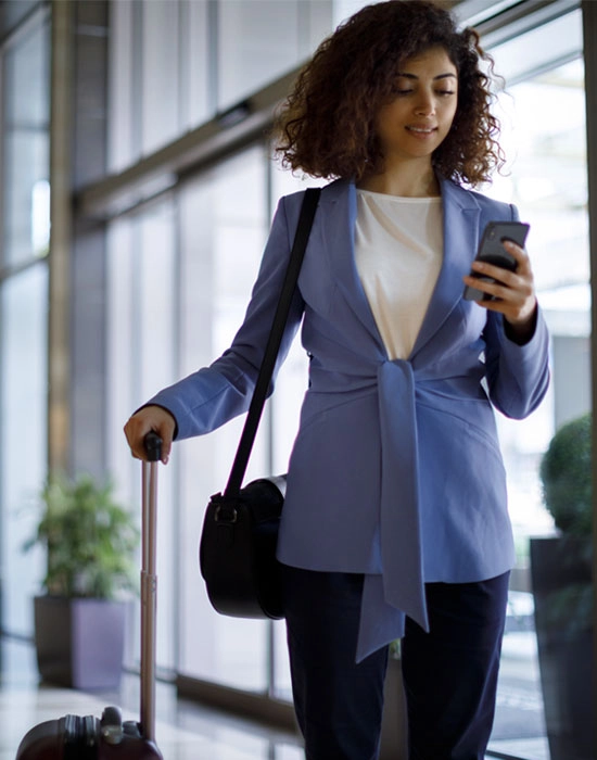 Lady with luggage at the airport checking exchange rate