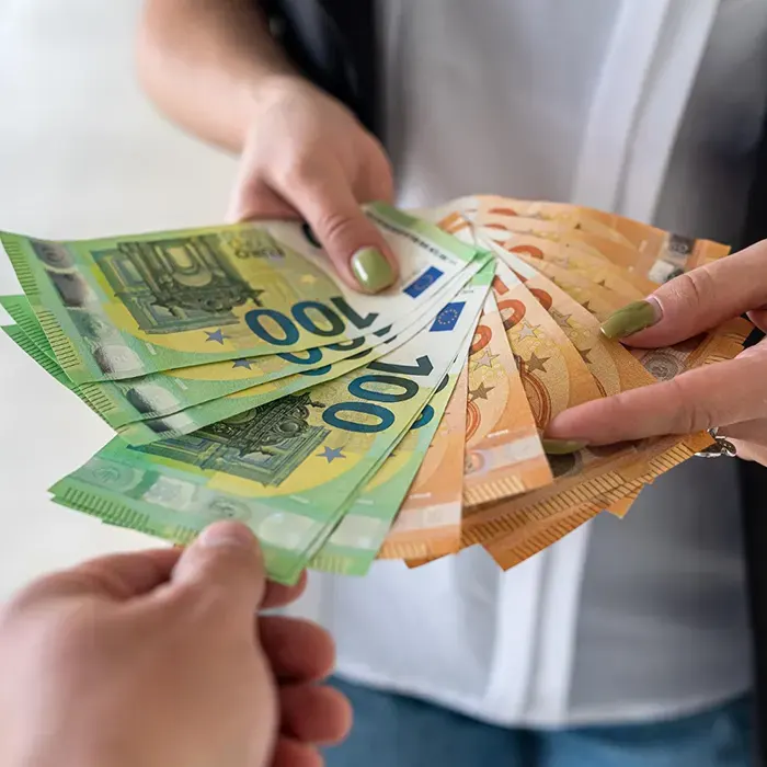 a lady giving foreign currency euro to other person