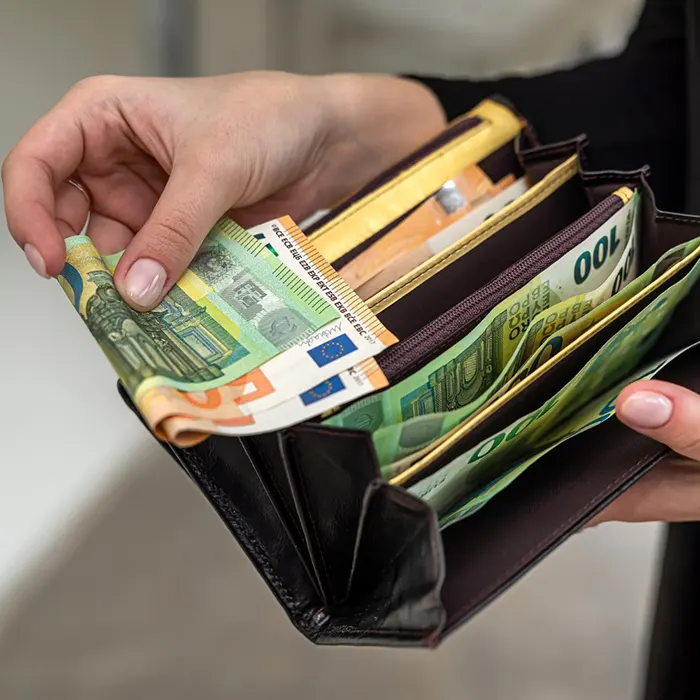 a man taking foreign currency euro from wallet