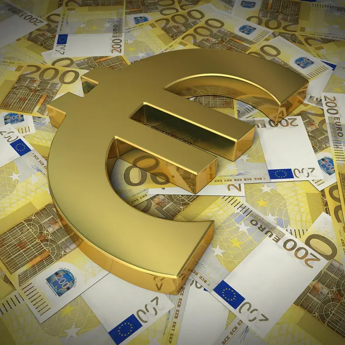 A large gold euro symbol is on a pile of euro currencies